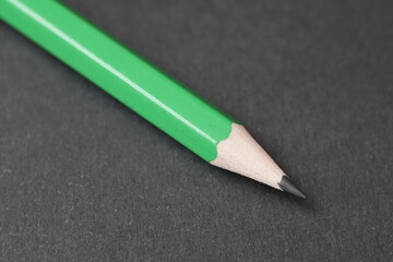 green pencil on a black background