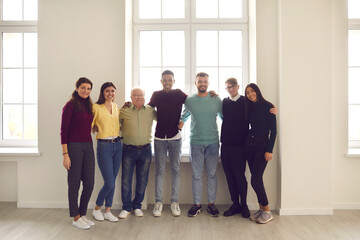 Group portrait by the window of happy positive diverse people of different genders, races and ages.