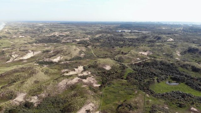 Coastal lowlands with small barren hills in Wijk aan Zee, North Holland, the Netherlands - Fly-Over Aerial shot