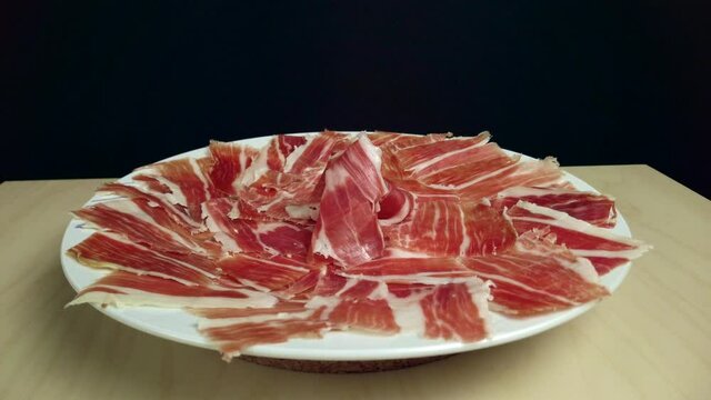 Different shots of a dish the typical Spanish product par excellence, ham from acorn-fed Iberian pigs (pata negra) just cut by hand.