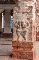 Hampi, Karnataka, India - November 4, 2013: Virupaksha Temple complex. Sculpted mural image on red stone pillar, turned white in spots, of 2 dancing women.