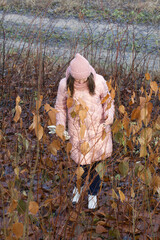 Girl in autumn clothes. Walking in nature in the park.