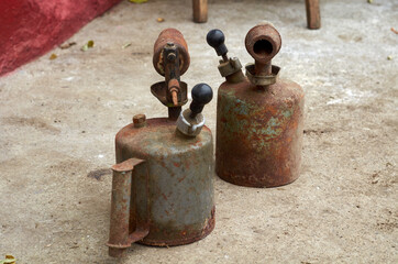 Photo of two gasoline blowtorchs on concrete