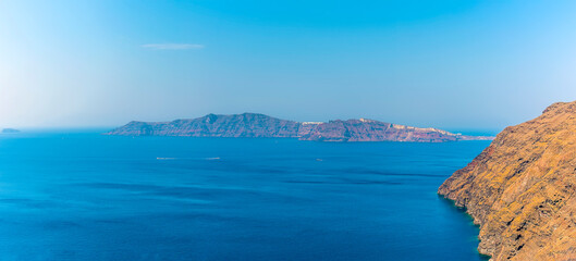 A view from the Caldera rim path towards Thirasia island in Santorini in summertime