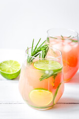 fitness cocktail in glass with lime and rosemary on white table background
