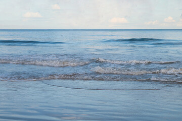 Nature background of seashore beach wave and coastline, clear blue sky with cloud, and sunlight water surface for holiday relaxation lifestyle landscape concept