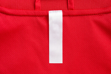 White blank clothes label on red jersey texture background