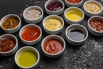 Many different sauces on black background