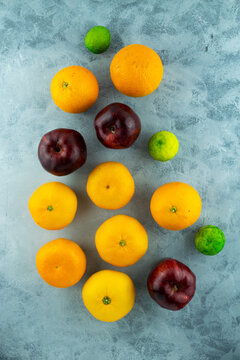 Overhead shot of oranges and apples on concrete surface