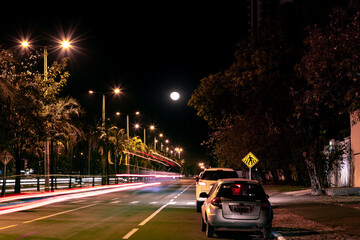 Fototapeta na wymiar Lua em longa exposição com carros passando em uma avenida na cidade de Palmas TO