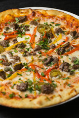 Pizza with vegetables and meat close up in restaurant