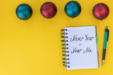 New year - new me. Inspiration concept. Writing in a notebook New year - new me on yellow...