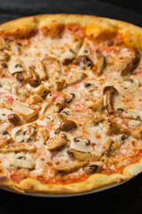 Pizza with chicken and mushrooms close up in restaurant
