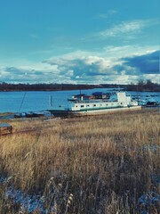 abandoned ship at the boat station against the background of the autumn evening sky