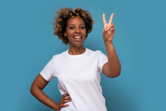 Young african woman showing two fingers, positive or peace gesture