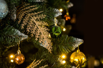 close-up of Christmas toys on the tree. Gold and green