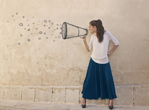 young woman screams into a magaphone drawn in a wall
