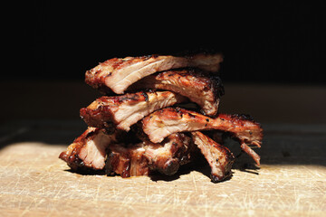 A mountain of meat. Pieces of meat are laid out uphill. Roasted pork ribs. Appetizing meat lies on a wooden tray.
Grilled meat