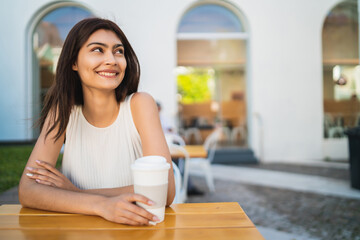 Young woman drinking a cup of coffee at coffee shop.