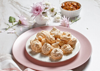 Fototapeta na wymiar Swirled meringue cookies with caramelized walnuts of egg whites whipped with sugar