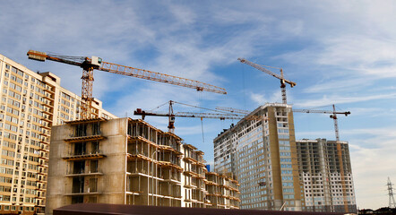 Construction site background. Cranes near buildings. Industrial background.