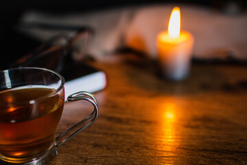 mesa de trabajo con taza de té alumbrado por una vela