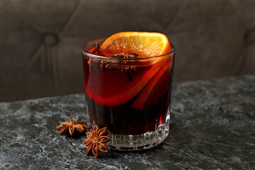 Glass of mulled wine on black smokey table