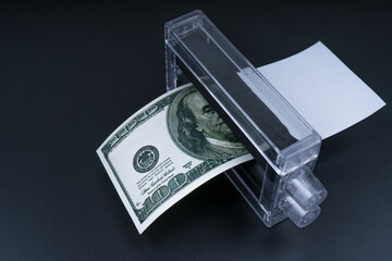 Dollar money printing machine on a black background. Business finance concept, counterfeiting, bank...