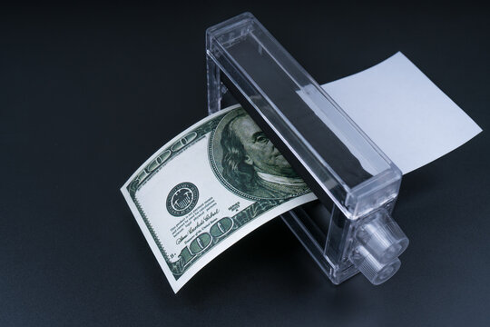 Dollar money printing machine on a black background. Business finance concept, counterfeiting, bank fake banknote