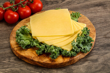 Sliced Gauda cheese over board