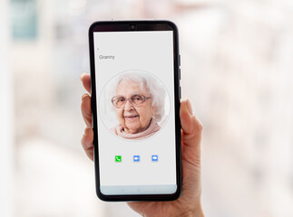 Woman holding smartphone with granny contact