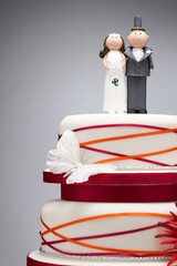 Comical bride and groom figurines on top of wedding cake