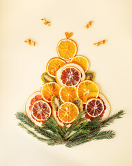 Holiday vibes. Christmas attributes. Dry oranges and cinnamon sticks in spruce branches on a wooden background