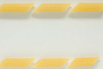 Close up of Penne noodles on white background; italian pasta frame