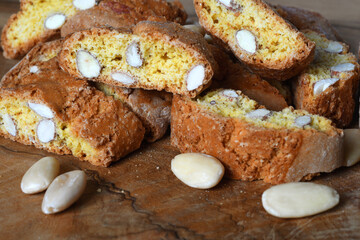 Close-up on cantucci or cantuccini on wooden background with shelled almonds. Cantuccini are typical Tuscan dry biscuits, made with flour, eggs, yeast and almonds. Italy.