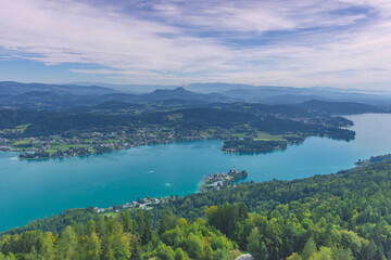 Fototapeta na wymiar Aerial view with the alpine lake Worthersee from The Pyramidenkogel, the highest wooden viewing tower in the world, famous tourists attraction in Carinthia region, Austria