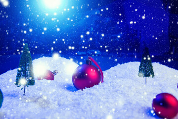 Christmas background with Christmas balls on snow over fir-tree, night sky and moon. Shallow depth...