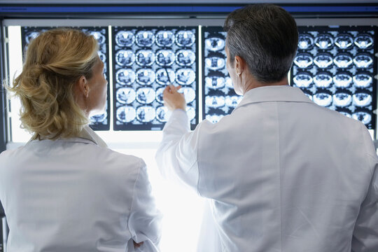 Rear View Of Doctors Discussing Brain Scans