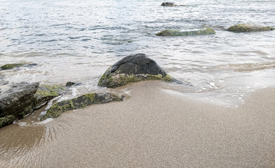 Beach on the sea with waves and stones in water