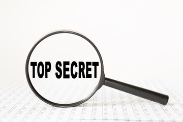 words TOP SECRET in a magnifying glass on a white background. business concept
