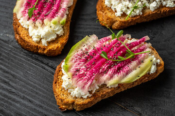 Healthy breakfast toasts from sliced watermelon radish and goat cheese. banner, catering menu recipe place for text, top view