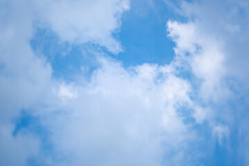 Blurred background of soft white clouds against blue sky background.