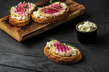 Delicious breakfast or snack vegetarian toasts from sliced watermelon radish and goat cheese. banner, catering menu recipe place for text, top view