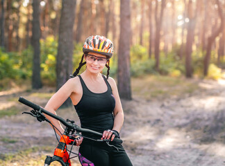 Naklejka premium Woman with bike in sunny forest