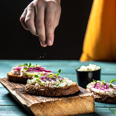 cooking toast with chia seeds with sliced watermelon radish or chinese daikon, cottage cheese and microgreen. freeze motion. banner, catering menu recipe