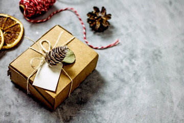 New Year's gift in sustainable gift wrap. Cardboard box tied with twine and decorated with a lump. Eco-friendly Christmas gift wrapping, copy space