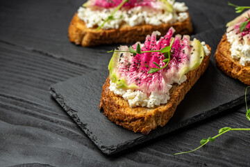 toasts from sliced watermelon radish with chinese daikon, cottage cheese and microgreen. Food recipe background. Close up