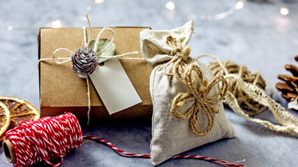 New Year's gift in sustainable gift wrap. Cardboard box tied with twine and decorated with a lump. Eco-friendly Christmas gift wrapping, copy space