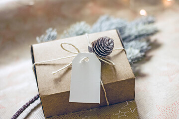 New Year's gift in sustainable gift wrap. Cardboard box tied with twine and decorated with a lump....
