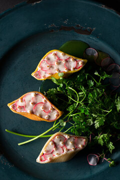 Conchiglioni Arlecchino filled with ricotta and radishes in a herb sauce